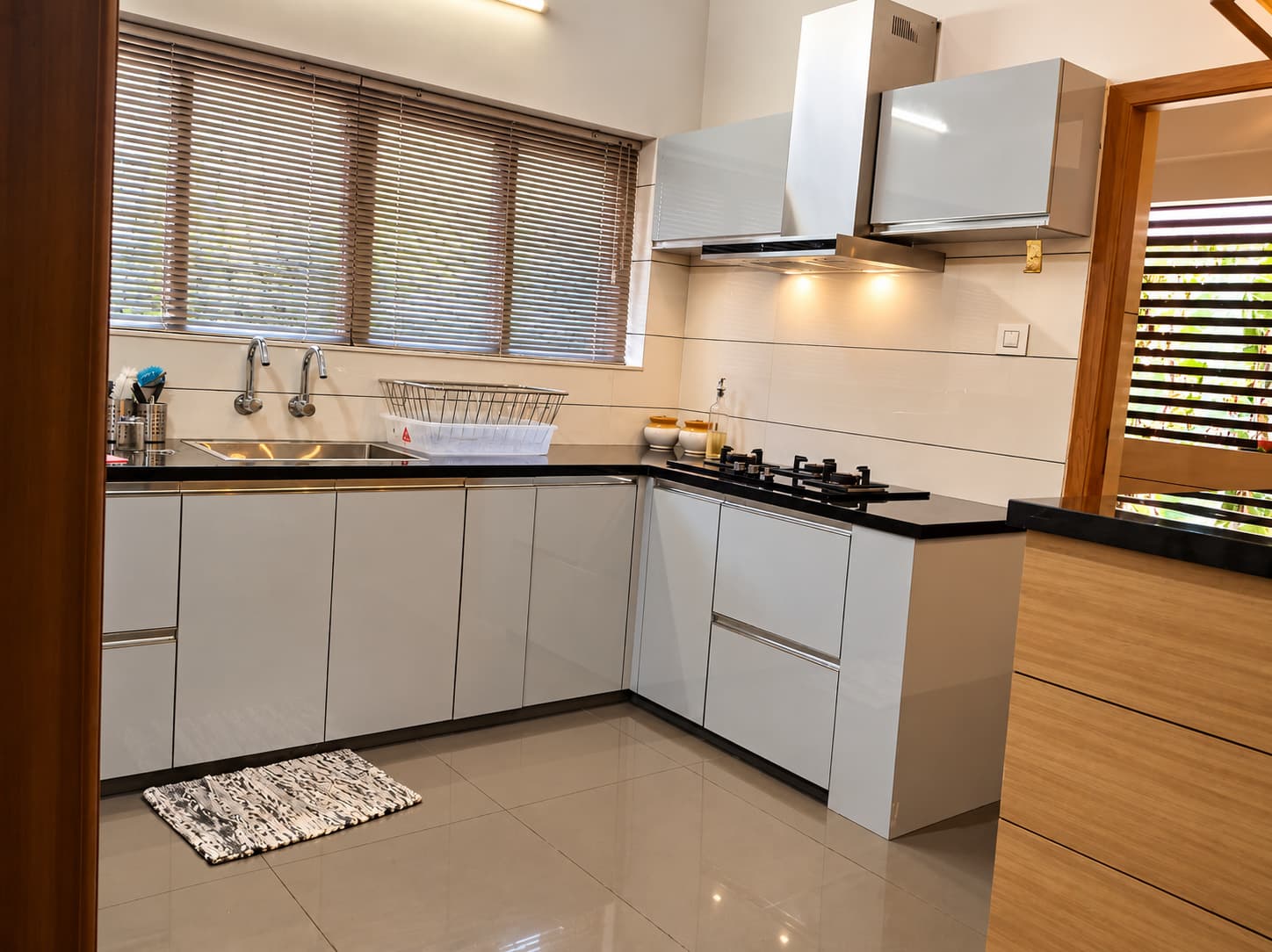 Kitchen with pale cabinetry, dark worktops and timber details