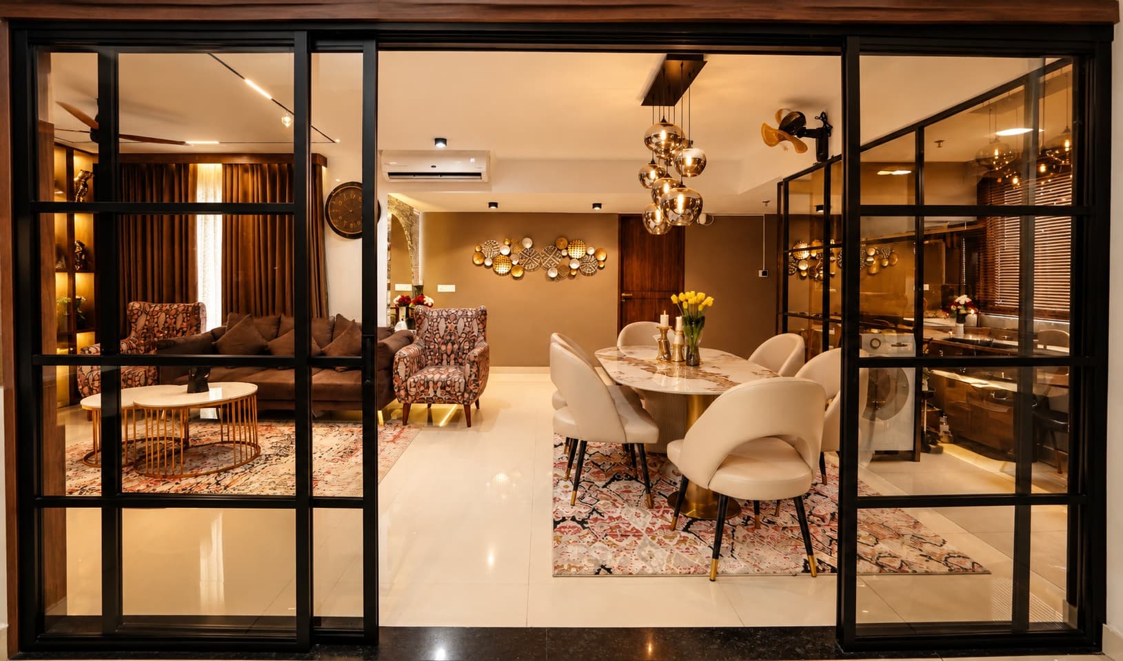 Dining table with cream chairs, patterned rug and warm pendant lighting