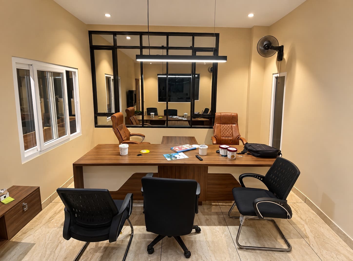 Meeting room at True Froot with a timber conference table, leather chairs and black-framed glass partition